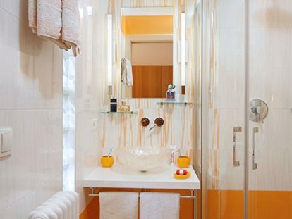 Pensionen - Dorf Tirol - Die Kombination von weiß und orange finden Sie auch in der modernen sanitären Anlage des orangen Doppelzimmers.   - Residence Sonnengarten**