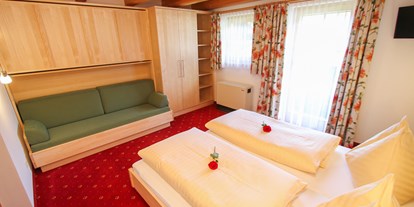 Pensionen - Kühlschrank - Pinzgau - Schlafzimmer von Uromas Stüberl  zwei bis vier Betten und Sitzcouch und Fernseher mit KTV - Urlaubsparadies Liebmannhof