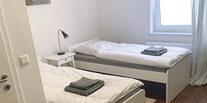 Pensionen - Umgebungsschwerpunkt: Strand - Ostfriesland - Doppelzimmer mit Einzelbetten, Handtücher und Bettwäsche, Nachttisch - Pension in Emden