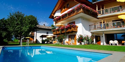 Pensionen - Wanderweg - Trentino-Südtirol - Haus Rosengarten, genau richtig für Erholung und Entspannung. Gepflegt-familiäres Haus in schöner sonniger Lage. Eine Oase der Ruhe, abseits von allem Verkehrslärm und doch nur 20 Gehminuten vom Dorfzentrum entfernt. Gemütlicher Aufenthaltsraum, großer Garten mit Liegewiese und Freischwimmbad. Für Ihr Auto steht ein eigener Parkplatz zur Verfügung - Haus Rosengarten 