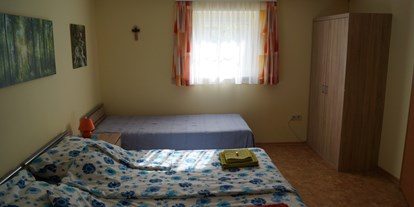 Pensionen - Teesdorf - Im Schlafzimmer sind 3 Betten, ein Kasten, 2 Nachtkästchen und ein Tisch mit 2 Stühlen. Ein Babybett kann ebenfalls gemietet werden - ist jedoch mit eigener Bettwäsche zu benutzen. - Appartment Robert