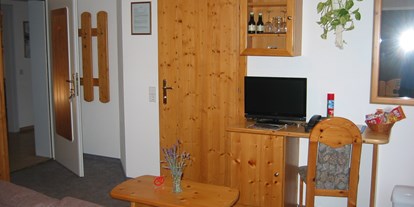 Pensionen - Umgebungsschwerpunkt: Berg - Thalgau - Fernsehecke Familienzimmer und Blick zum Eingang ins Bad und Zimmers - Gästehaus Heidi - Ihr Gästehaus mit Herz und Flair